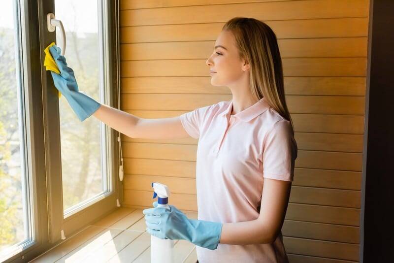 Housekeeper cleaning window sill